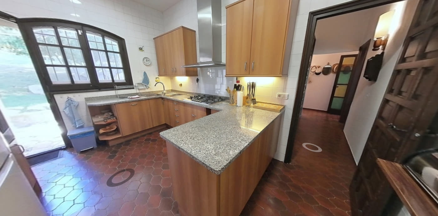 Cocina con encimera de granito, suelo de barro y ventana en arco