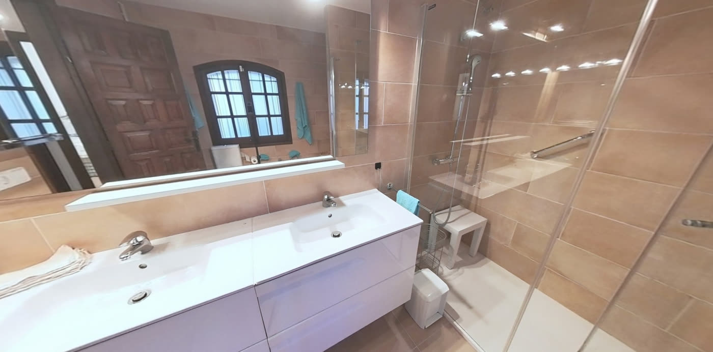 Baño con doble lavabo y ducha de obra