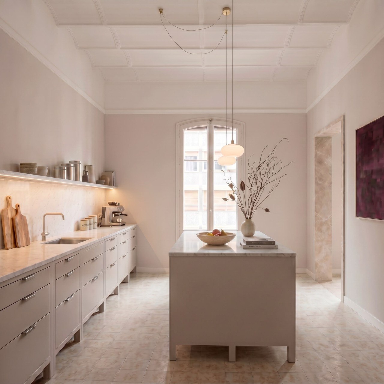 Cocina con isla central de mármol y techo artesonado blanco