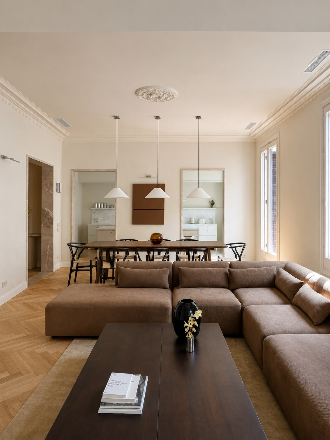 El salón desde dentro, con el sofá modular en primer término y el comedor al fondo bajo el rosetón restaurado