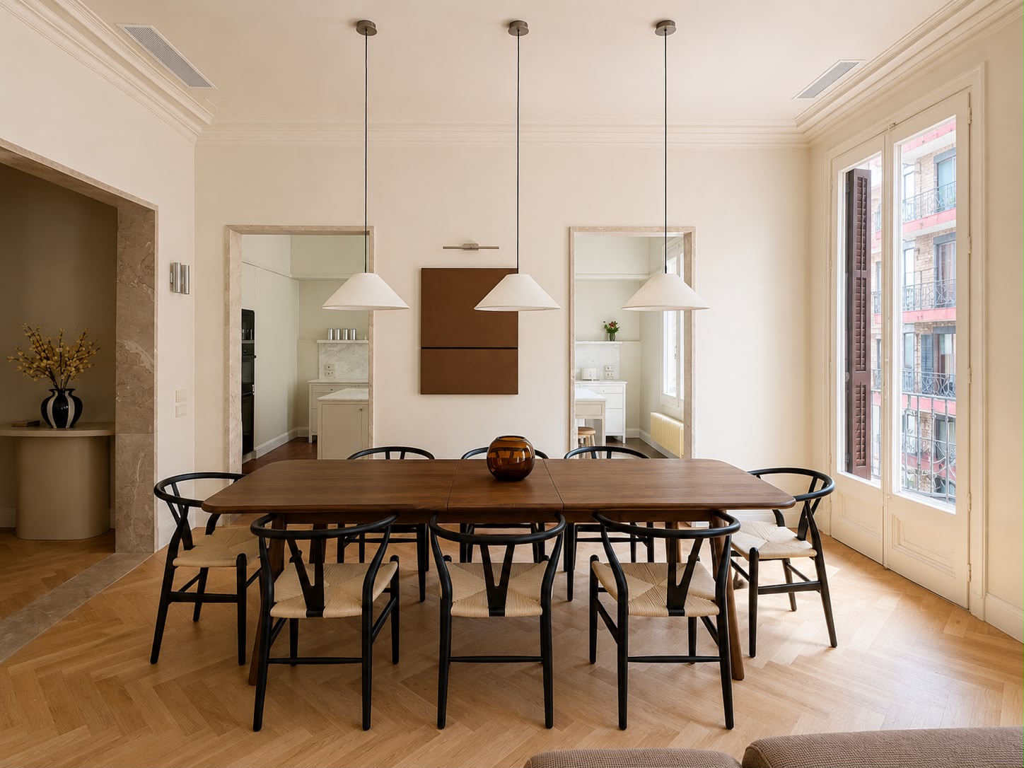 Comedor con mesa de nogal, sillas de madera y los balcones con las contraventanas abiertas
